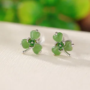 Hetian jade shamrock stud earrings in 925 sterling silver, top-down flat lay view showing delicate clover design with green jade stones