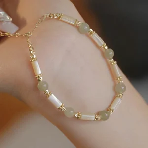 Hetian jade beads with shell tube spacers and gold metal hardware adjustable bracelet, flat lay studio product display