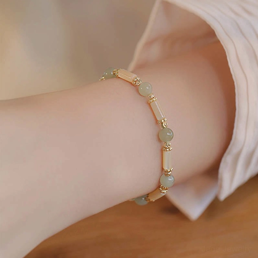 Hetian jade bracelet with shell tube beads worn on wrist with formal shirt sleeve, professional styling showcase