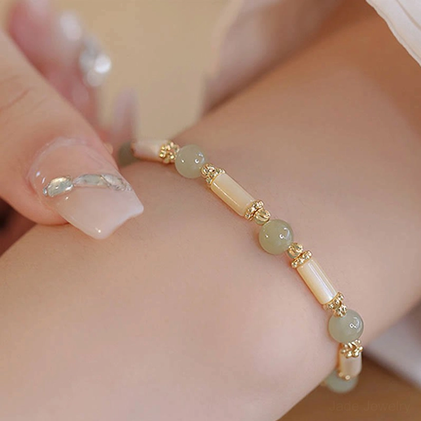 Hetian jade and shell bead bracelet close-up on wrist with manicure detail, premium stone quality showcase