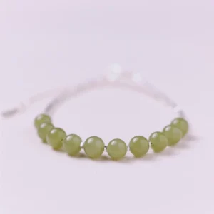 Hetian jade bead bracelet side flat lay showing smooth polished jade beads paired with sterling silver segments