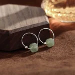 Hetian jade sterling silver hoop earrings front view showing light green jade beads on polished silver hoops