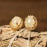 Natural Hetian jade stud earrings with gold halo setting and cubic zirconia accents, front top view