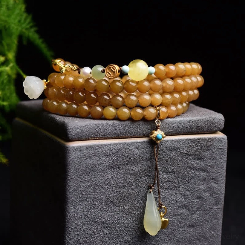 Natural jade bracelet set with mixed gemstones displayed on grey stone with botanical background