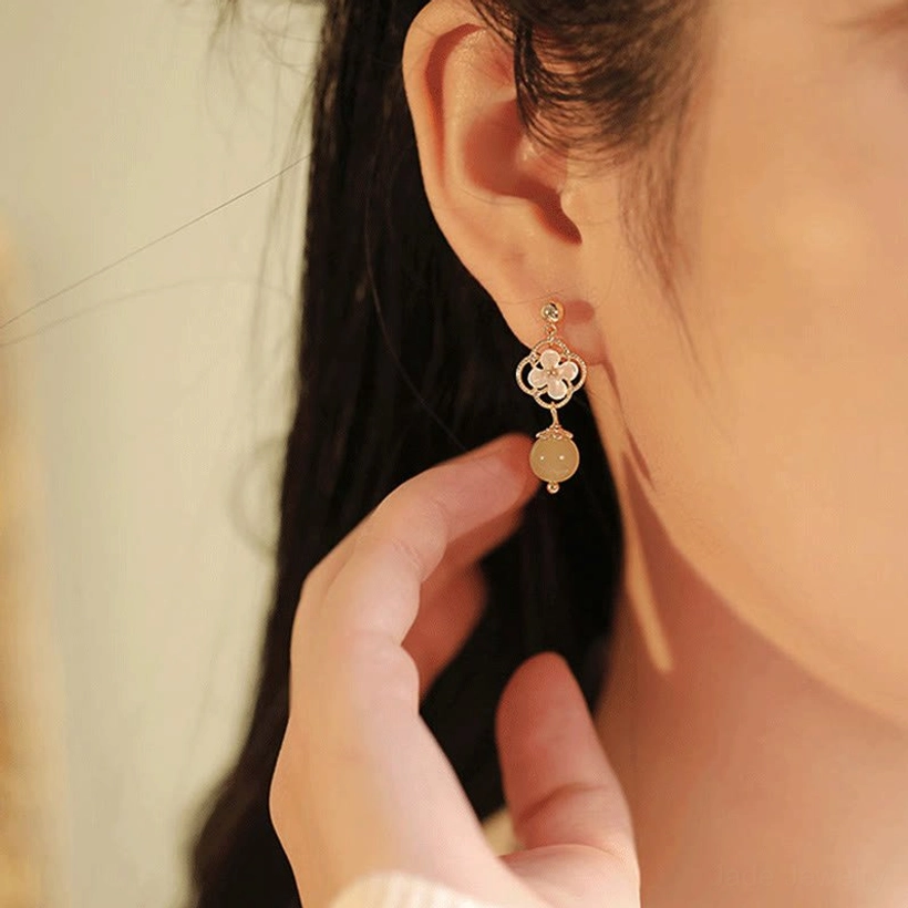 Hetian jade and tridacna stone flower drop earrings, detail shot of the intricate floral carving and precious jade bead