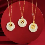 Chinese zodiac Hetian jade necklaces collection flat lay overhead view showing all zodiac animal pendants with sterling silver chains on deep red background