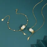 Hetian white jade bamboo necklace and bracelet set featuring handcrafted bamboo-shaped jade charms with leaf tassel pendants, available in sterling silver and gold-plated metal options, displayed in flat lay on dark teal studio background