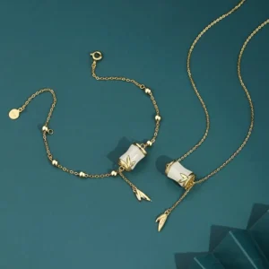 Hetian white jade bamboo necklace and bracelet set featuring handcrafted bamboo-shaped jade charms with leaf tassel pendants, available in sterling silver and gold-plated metal options, displayed in flat lay on dark teal studio background