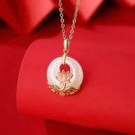 Hetian white jade lotus pendant necklace with 925 sterling silver - front close-up showing delicate white jade with pink enamel lotus detail on red fabric background
