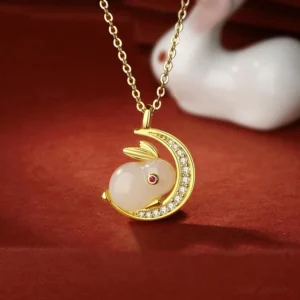 Hetian white jade rabbit moon pendant necklace with sterling silver setting and cubic zirconia accents on red fabric background - handcrafted celestial talisman