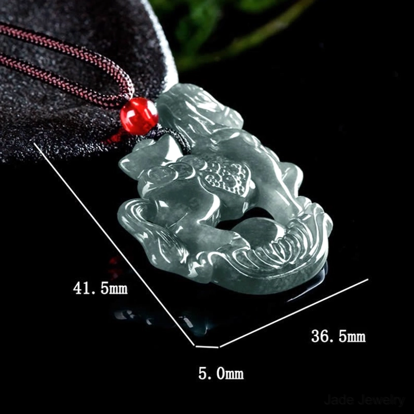 Horse zodiac jade pendant necklace detail showing brown hand-dyed rope cord with red accent bead against dark background highlighting cord craftsmanship and bead color contrast