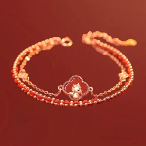 Horse zodiac sterling silver jade bracelet featuring central clover horse ornament, adjustable tail chain, and red beaded chain layer shown at oblique angle