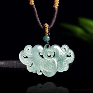 Icy green jade phoenix pendant necklace with intricate hollowed carving, front overhead view showcasing the fine artistry and natural jade texture against dark studio background