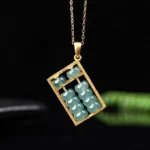 Gold-tone natural jade abacus necklace pendant with blue-green jade beads in traditional abacus pattern, front view on dark background