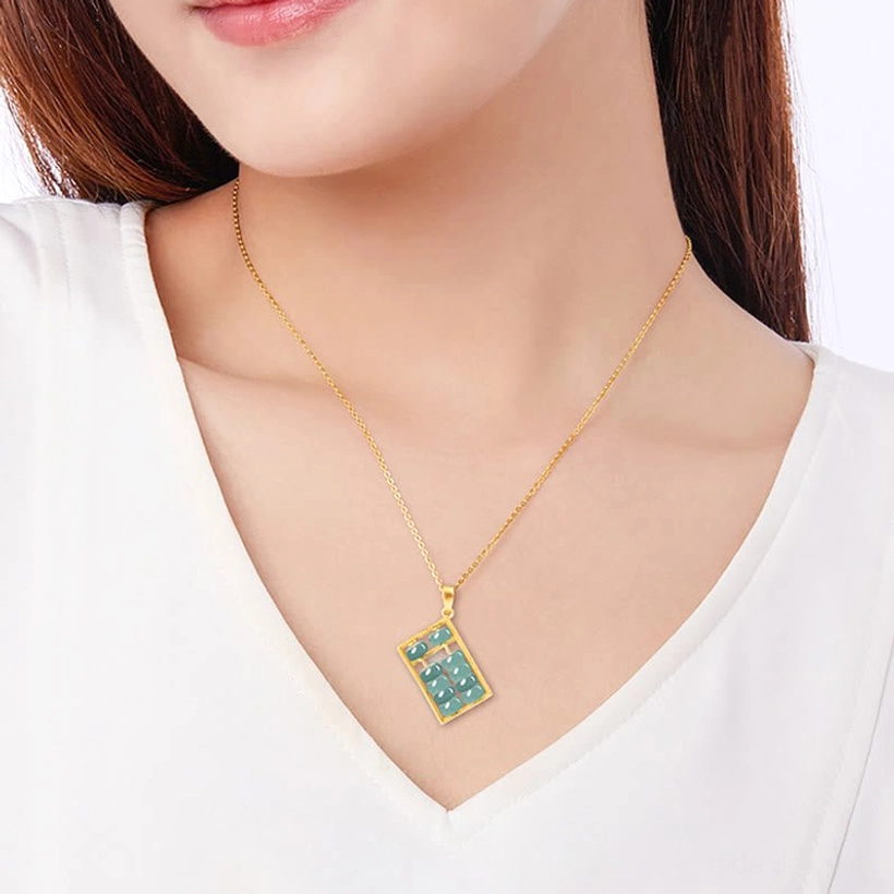 Woman wearing gold-tone jade abacus necklace at collarbone, lifestyle portrait showing delicate pendant wear