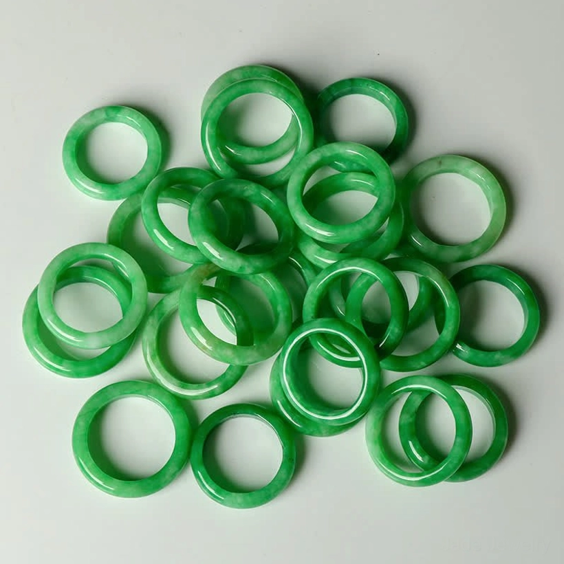Multiple loose jade prosperity rings bright green smooth polished surfaces top view