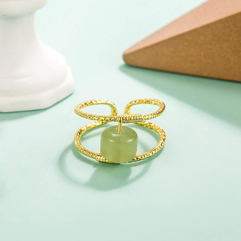 Light green round jade bead adjustable ring with twisted gold copper bands, front top view on mint backdrop