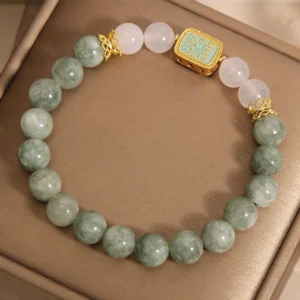 Hah Taew blessing bracelet with pale green jade and milky white agate beads on velvet display pad