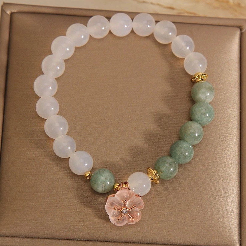 Full layout of white agate jade flower charm bracelet on brown jewelry box