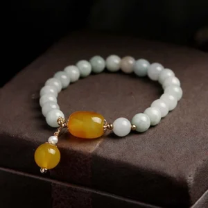 Tristone jade agate protection bracelet displayed on brown leather box side angle