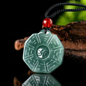 Three-quarter view of jade Bagua Yin Yang feng shui necklace showing polished light green jade with engraved trigram patterns