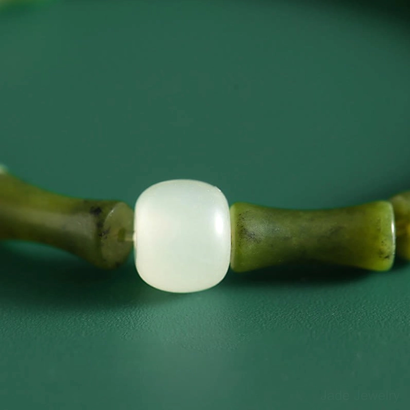 Macro close-up detail of white jade bead connected to green bamboo joint jade beads, macro photography