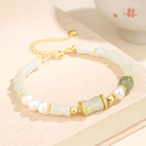 Adjustable hetian white jade bracelet with extender chain and premium buckle closure on wooden display tray