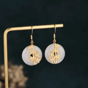 White jade drop earrings hanging display - jade dangle earrings on jewelry display stand showcasing length and design