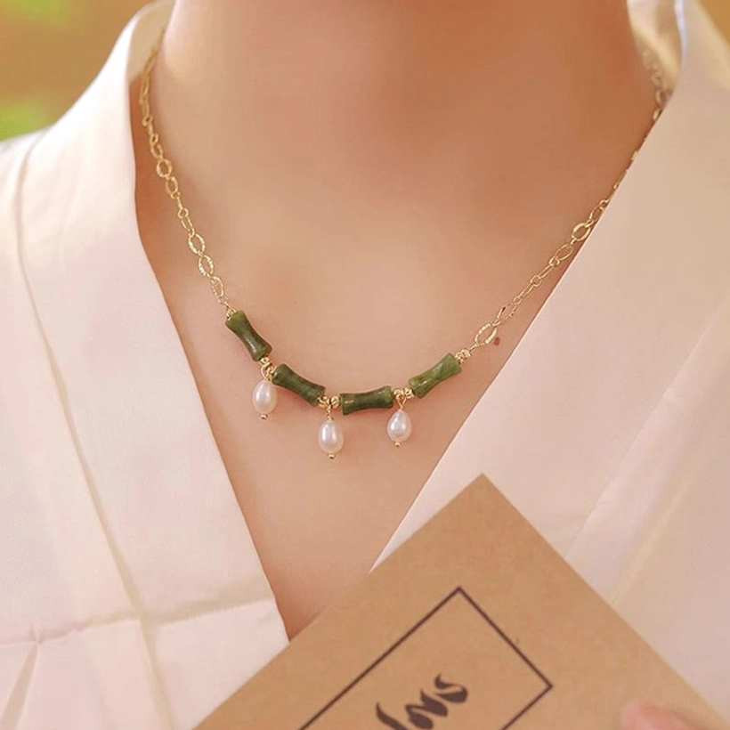 Front view of woman wearing Tianshan jade bamboo pearl necklace with three drop pearls