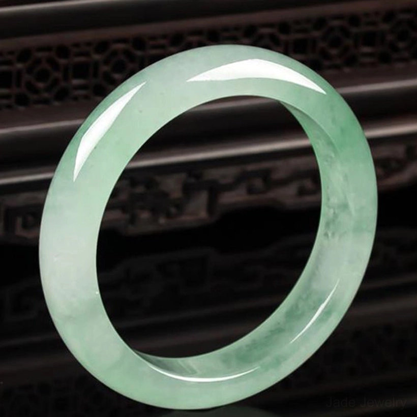 Jade bangle bracelet curved side angle view showing smooth polished surface and natural jade color