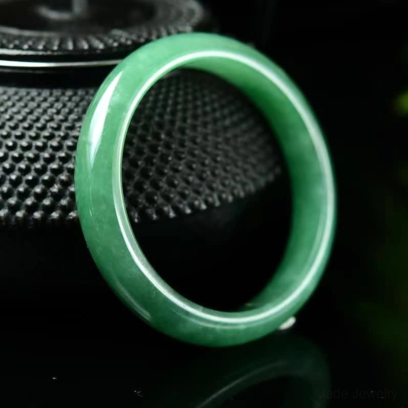 Front view of dark green natural jade bangle showing smooth ring design and solid jade craftsmanship
