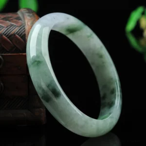 Authentic jade bangle bracelet side profile showing pale lavender and green tones with natural jade veining patterns