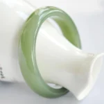 Green jade bangle bracelet three-quarter view showing polished rounded band style
