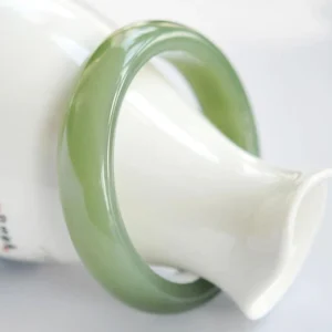 Green jade bangle bracelet three-quarter view showing polished rounded band style