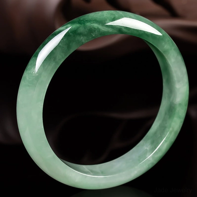 Authentic jade bangle showing side profile with smooth polished edge and natural dark green patterns