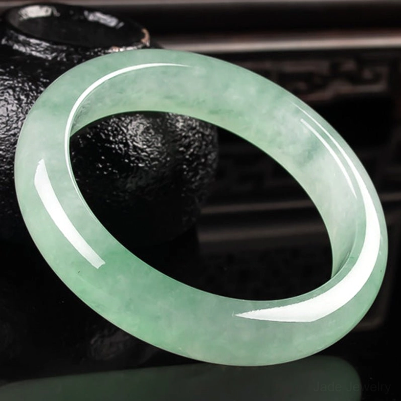 Jade bangle bracelet side profile showing smooth rounded band and authentic light green jade stone color