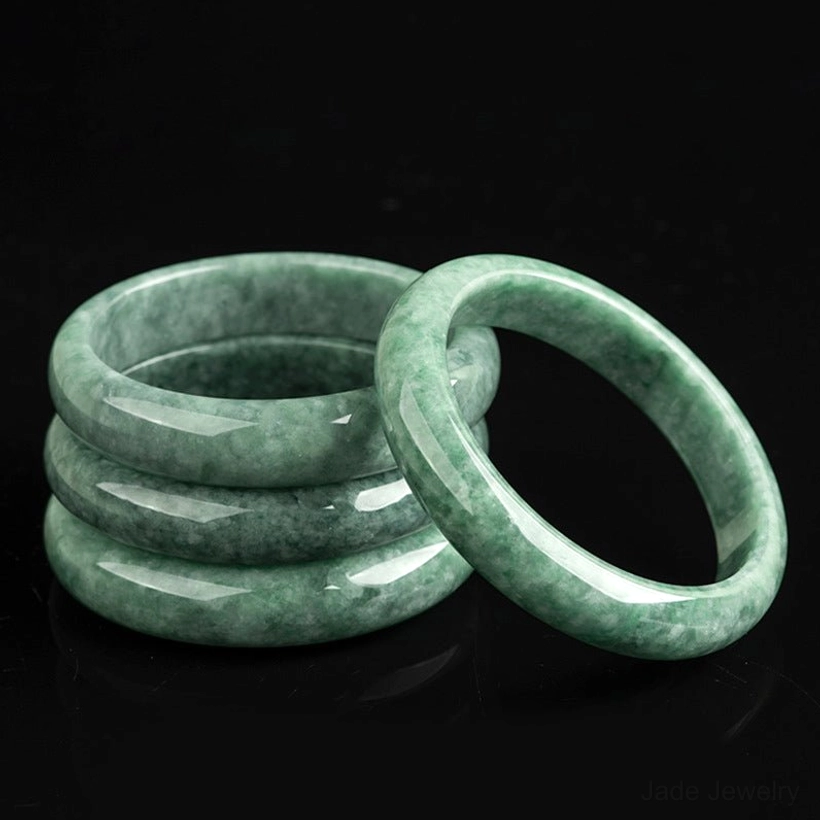 Natural jade bangle bracelet close-up detail shot showing authentic stone texture, polish quality, and jade color variations