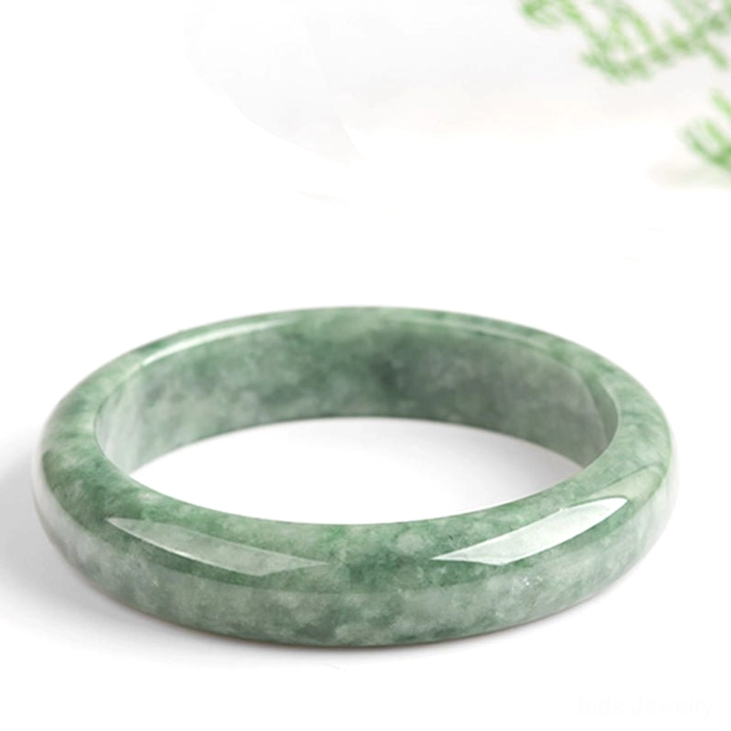 Flat lay jade bangle bracelet top-down view on white background, displaying even green mottled texture and polished finish