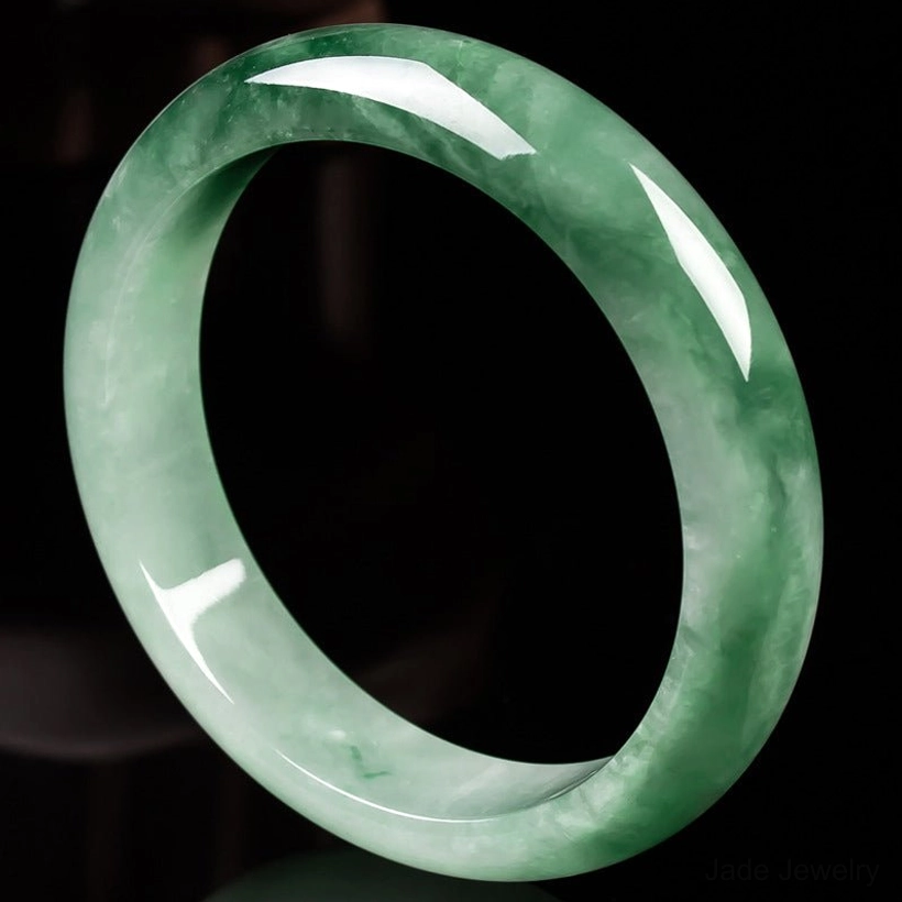 Smooth gradient green jade bangle with natural floating veins and polished finish, overhead angle