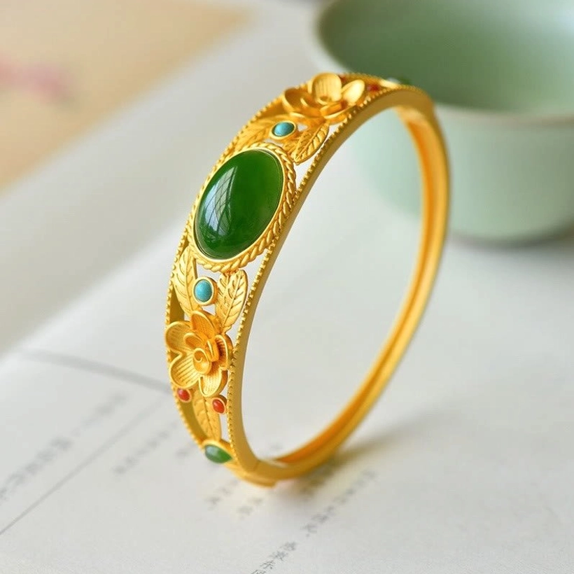 Premium jade flower bangle with polished green jade center, hollow floral filigree design, and fine gold metalwork
