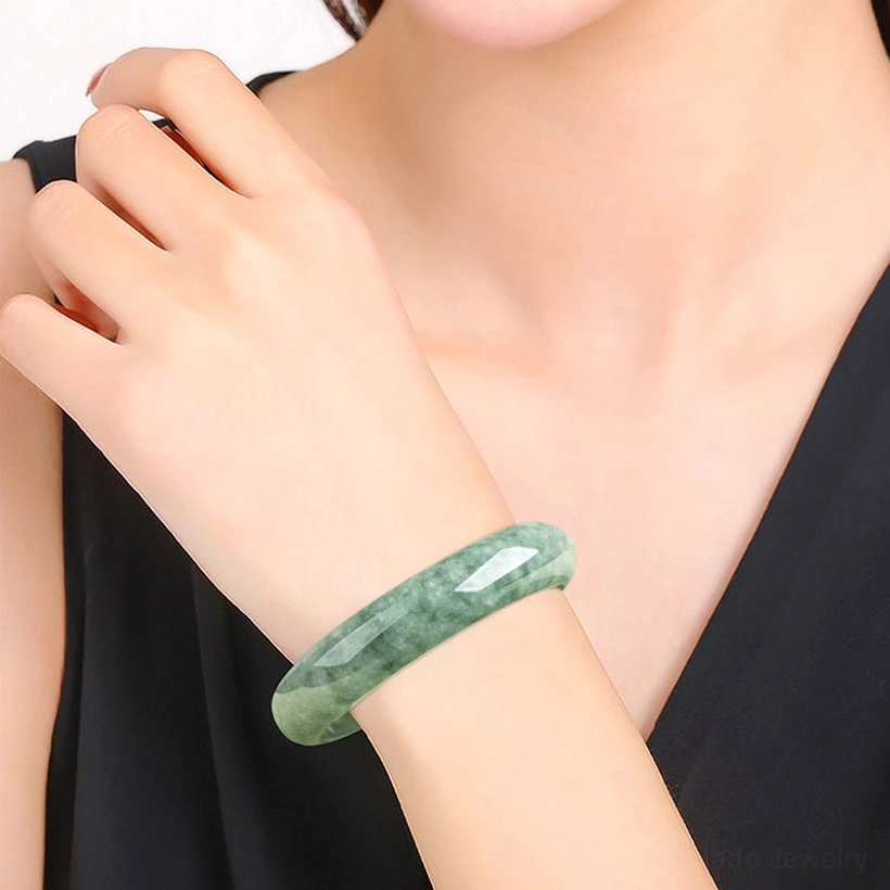 Jade bangle bracelet worn on wrist in daily wear, demonstrating comfortable fit and elegant styling with black sleeveless top