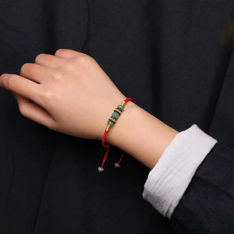 Red string jade prosperity bracelet detail shot highlighting authentic green jade beads and premium red rope
