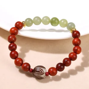 Handmade jade bracelet flat lay on white ceramic with rosewood and carved bodhi seed centerpiece
