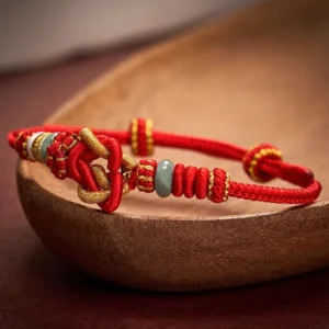 Close-up side view of woven jade bracelet with adjustable rope clasp and metal beads