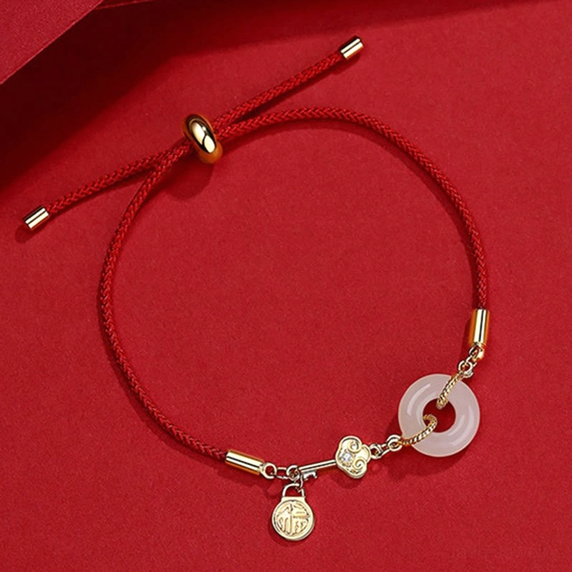 Side angle view of adjustable red cord jade bracelet showing sliding adjuster and heart charm