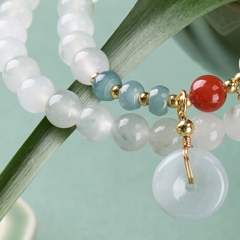 Close-up of jade peace buckle bracelet charm beads and gold hardware accents