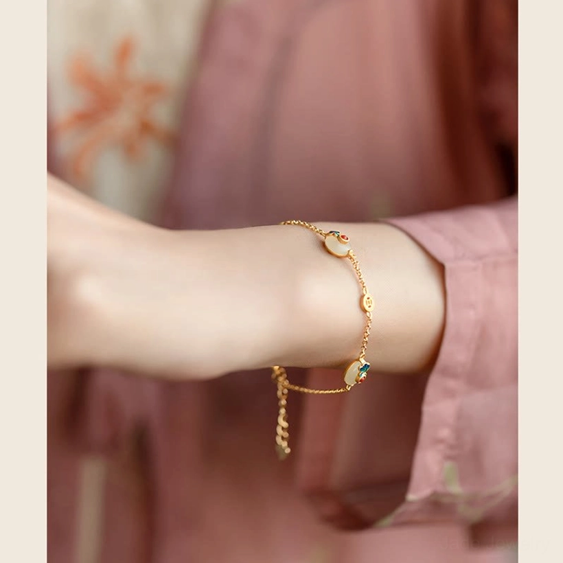 Delicate Auspicious Clouds Jade Bracelet detail showing gold chain with jade and enamel beads on pink floral background
