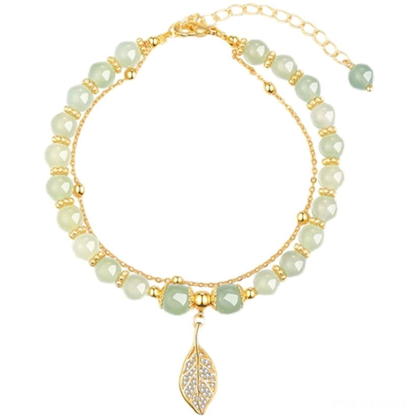 Faceted light green jade beads bracelet with gold spacers and hollow leaf pendant flat lay