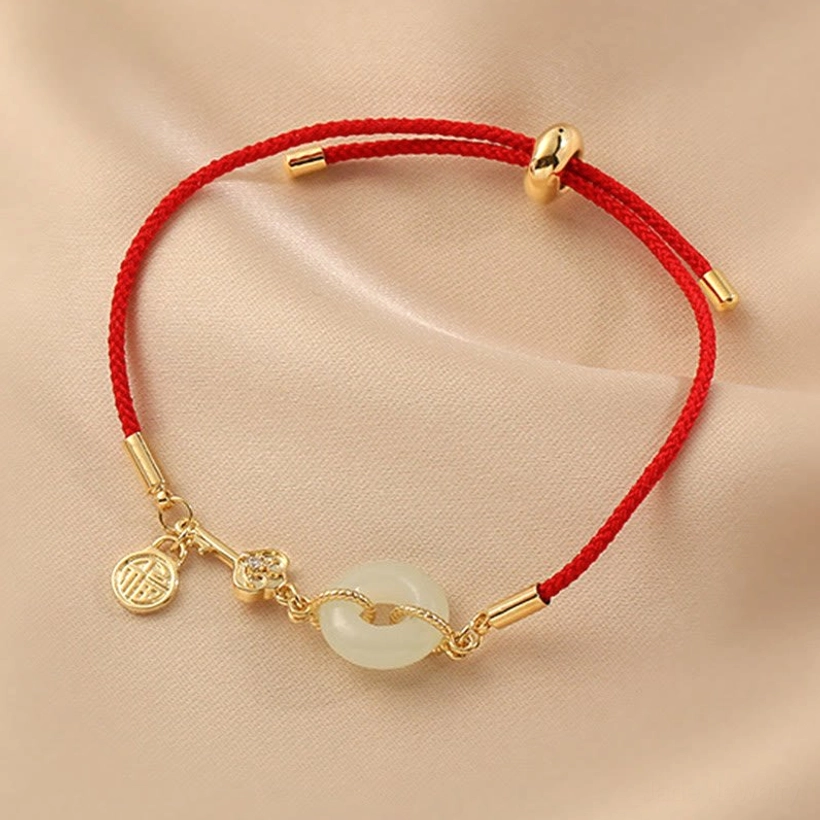 Red string jade bracelet showing Fu character pendant representing happiness and good fortune