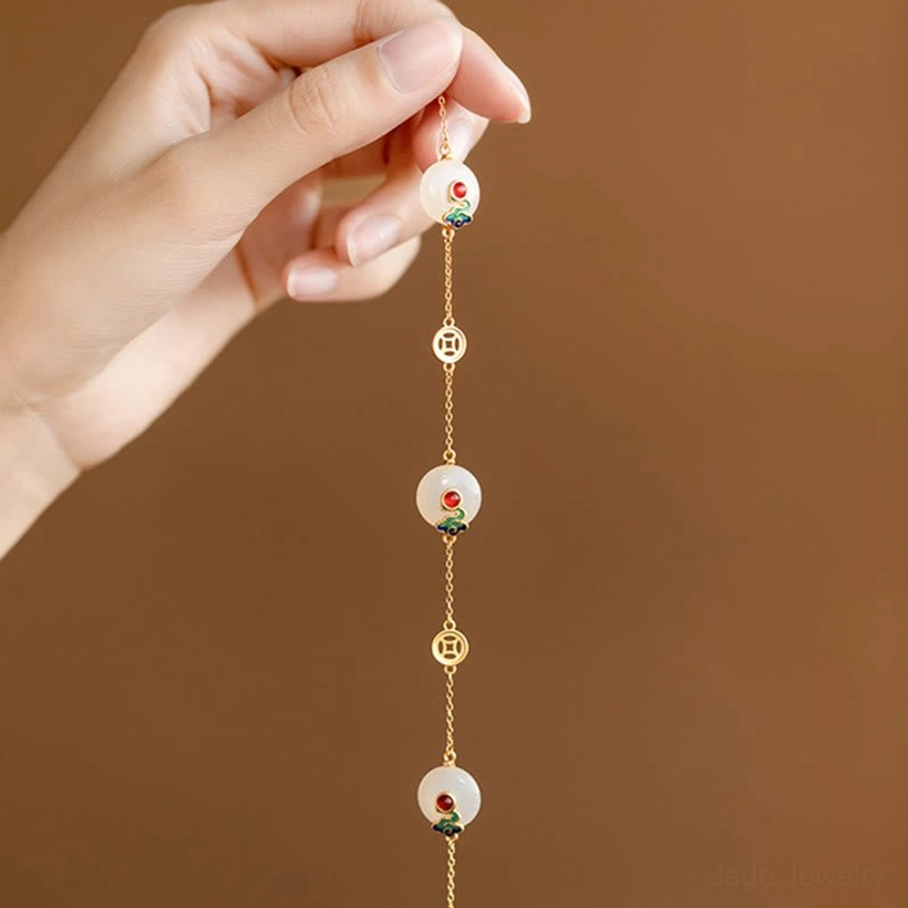 Close-up overhead view of Auspicious Clouds Jade Bracelet worn on hand with dangling jade and coin charms